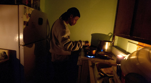 The gas is on, so Richard Bates can cook by candlelight, but life has been hard in Brooklyn’s Red Hook Houses and for tens of thousands of other public housing residents without heat, water or power since Hurricane Sandy hit. No lights or elevators function in their 12-story buildings. – Photo: Ruth Fremson, New York Times